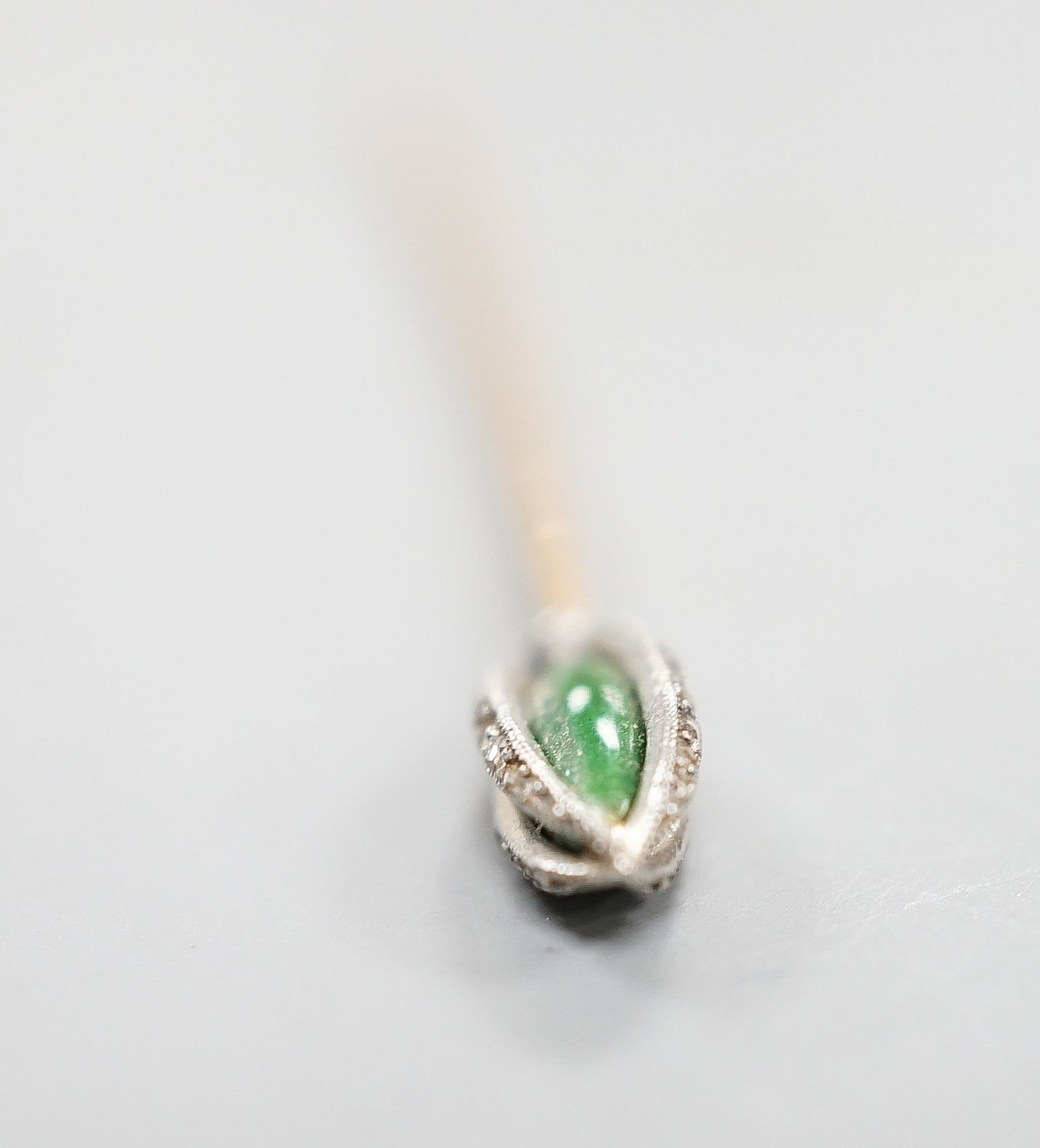 An early 20th century yellow metal stick pin, with rose cut diamond and green enamel set terminal, 76mm, gross weight 2.3 grams.